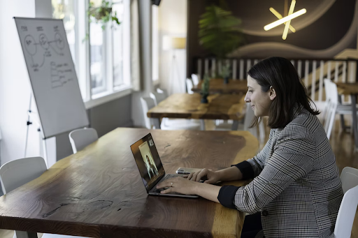 dennison image woman smiling at a video call on her computer in an office